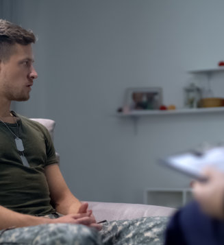 A man in military uniform sits on a couch