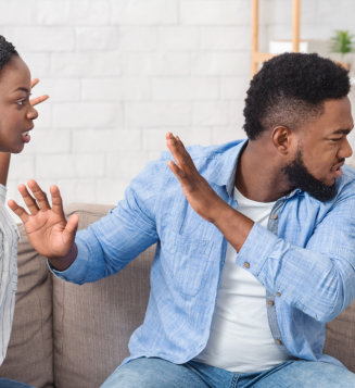 couple arguing on sofa at home