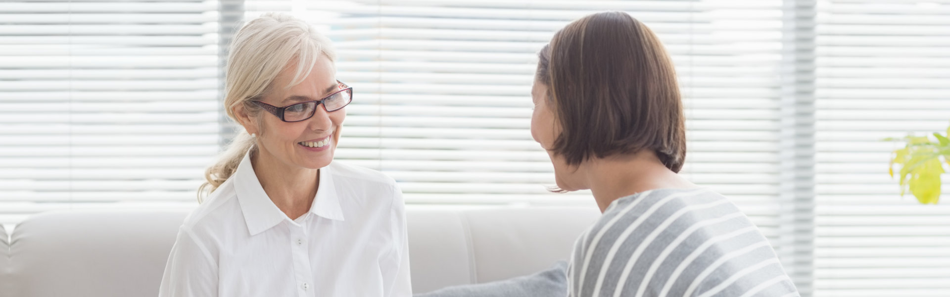 Smiling therapist with woman on sofa